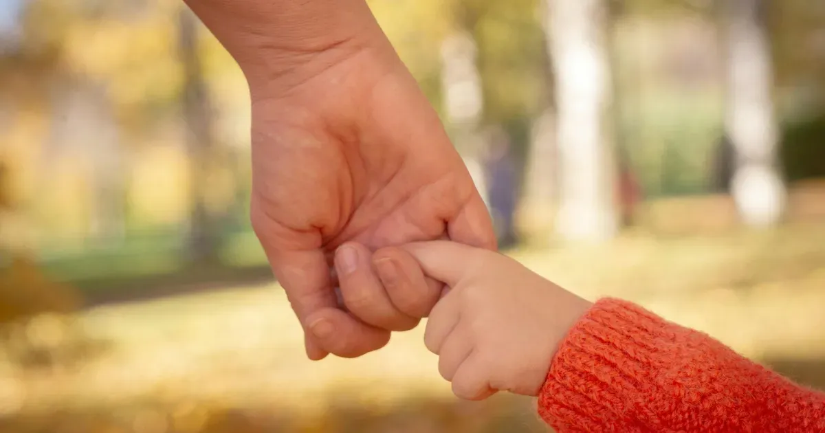 Adulto consolando a un niño al explicar la muerte de un ser querido